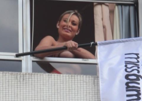 Andressa Urach faz topless em janela de hotel com a bandeira do Miss Bumbum